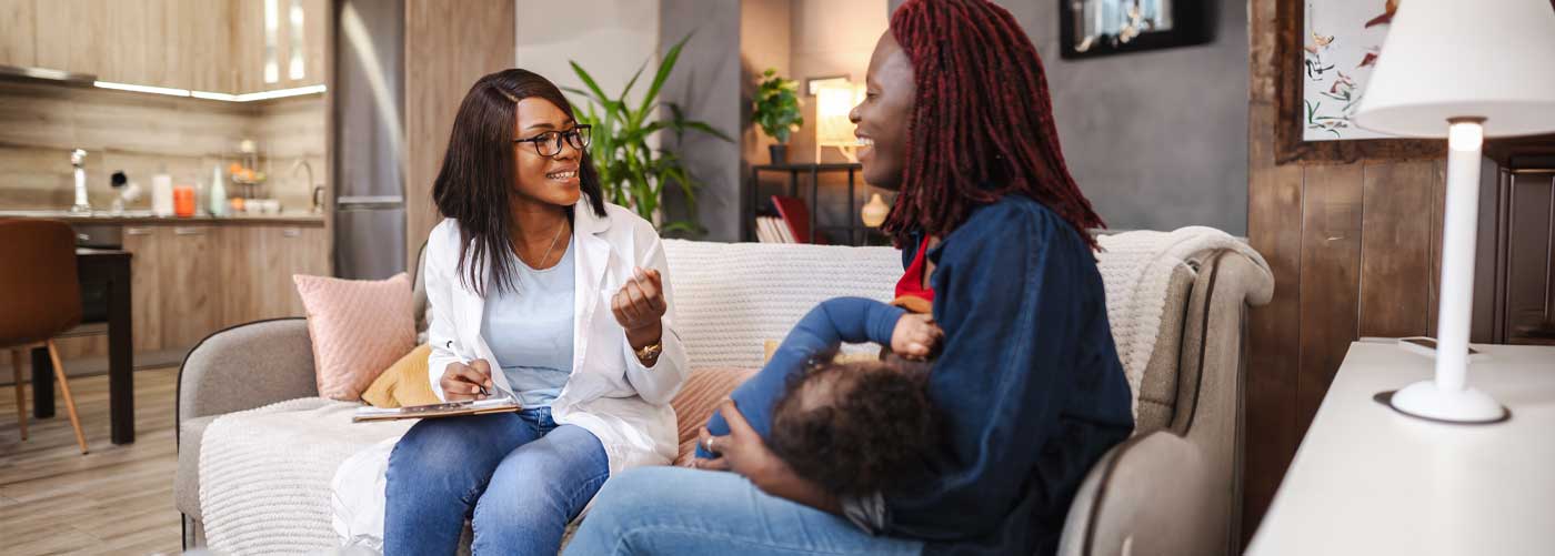 Nurse visiting new parent and baby in home