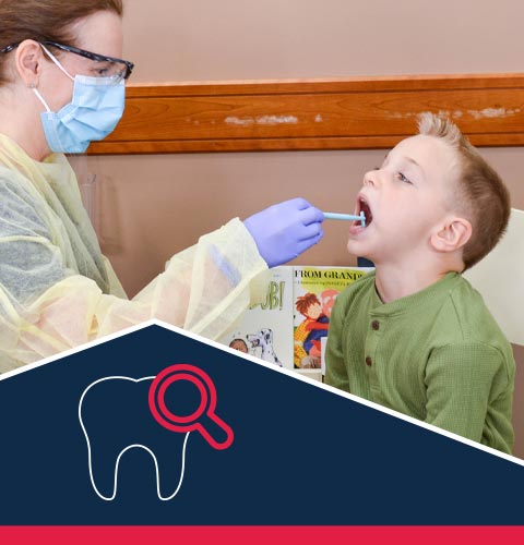 Dental hygenist looking in child's mouth