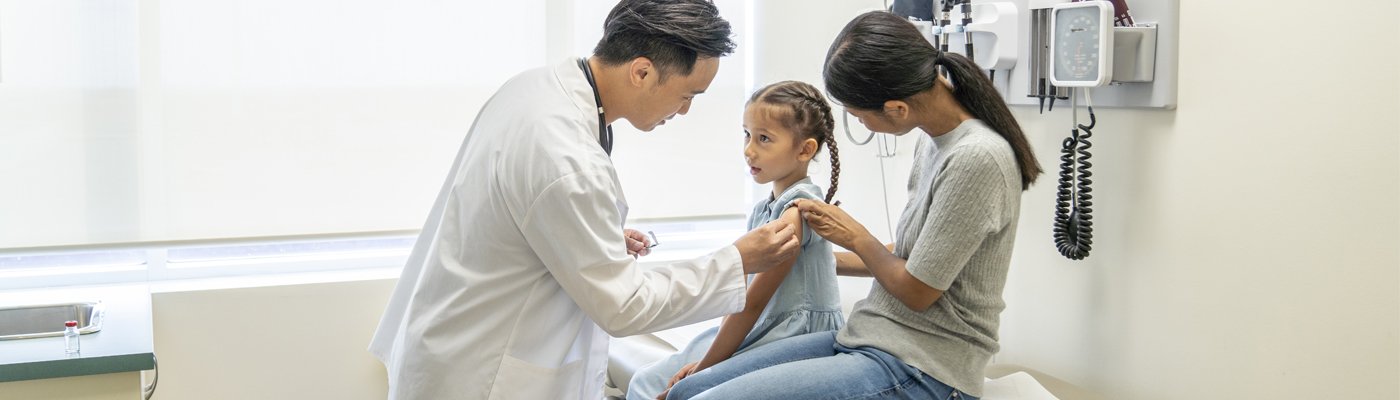 doctor, child and caregiver in a doctor office 