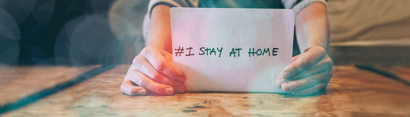 Hands holding paper that says #I stay at home