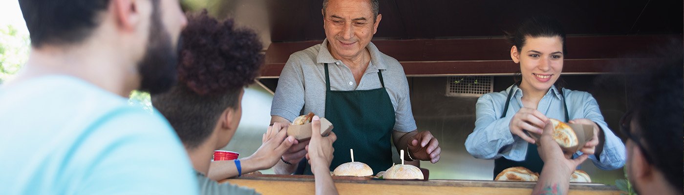 Food vendors handing food to customers